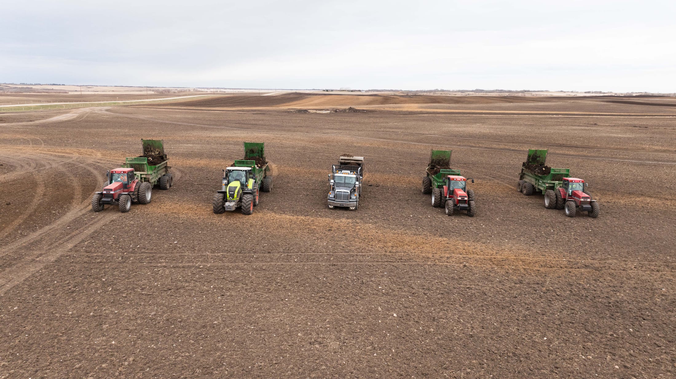 Lazy T Ranch equipment fleet working across the open Saskatchewan prairie